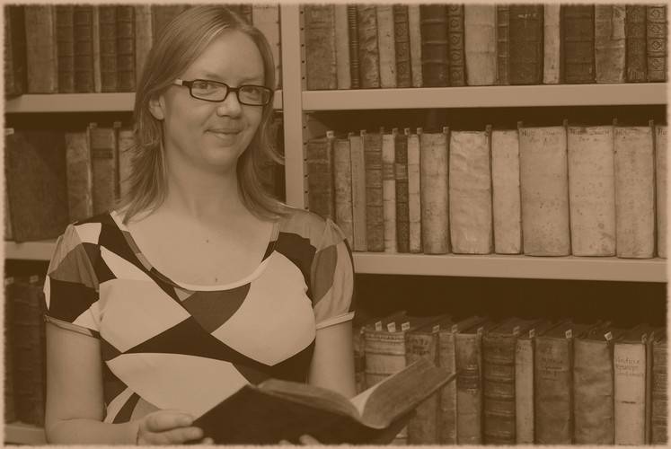 une femme devant un mur de livres